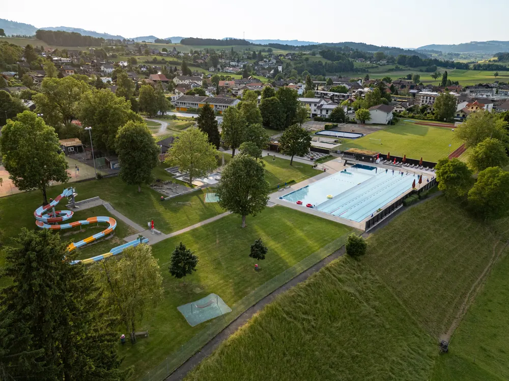 Luftaufnahme der Badi Uetendorf mit Schwimmbecken und Rutschbahn